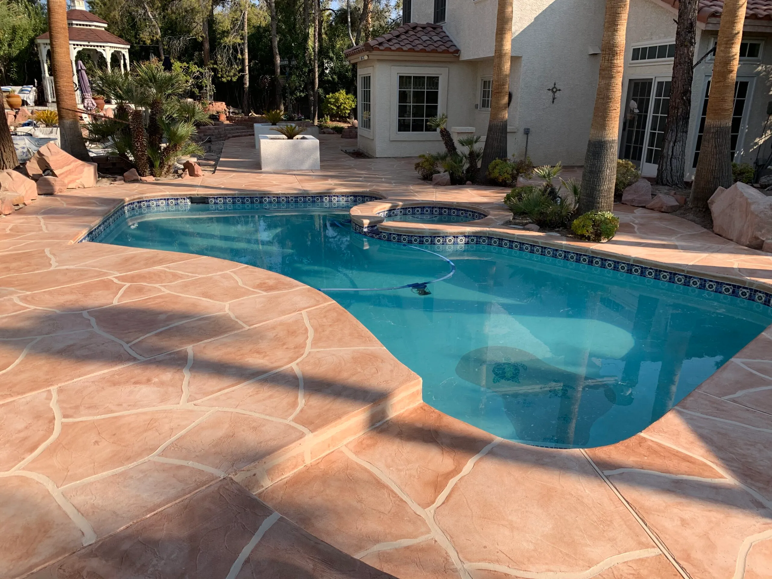Decorative concrete pool deck surrounding an in-ground pool
